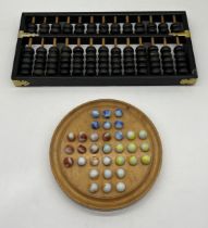 A vintage Chinese Lotus Flower abacus along with a Jaques marble Solitaire game.