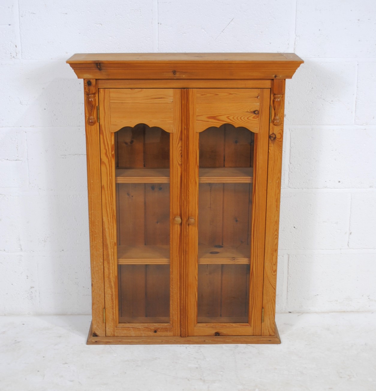 A pine glazed two door cabinet - length 71cm, depth 20.5cm, height 95cm