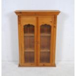 A pine glazed two door cabinet - length 71cm, depth 20.5cm, height 95cm