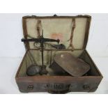 A vintage leather suitcase containing two sets of scales and a brass car horn (A/F)