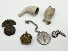 A small collection of items including a Royal Munster Fusiliers cap badge