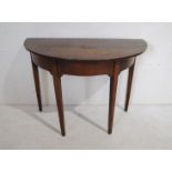 An antique oak demi-lune table, raised on tapering legs - length 105cm, depth 55.5cm, height 74.5cm