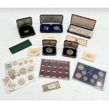 A collection of cased coins and coin sets including a silver set of two commemorative medals for the