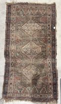 A red ground Eastern rug, with geometric designs - some wear - 163cm x 85cm