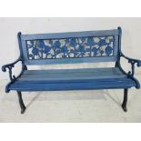 A vintage garden bench with cast iron ends and rose design back panel