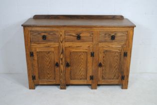 An oak sideboard, with three drawers and cupboard under - length 137.5cm, depth 45cm, height 93cm