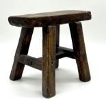 A small rustic four legged elm stool