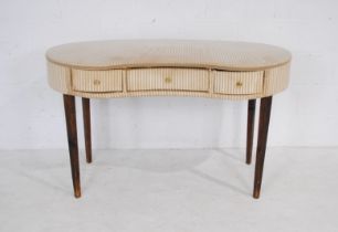 An upholstered kidney shaped dressing table with detachable skirts, with three drawers, raised on
