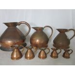 A matched set of eight antique and later copper jugs ranging from 4 gallon to 1/8 Gill