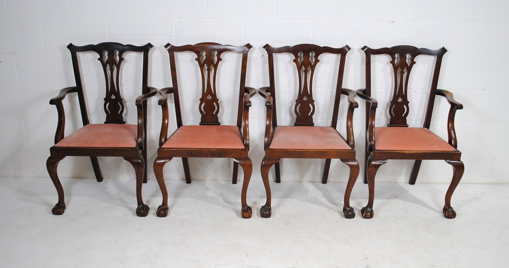 A set of four Hepplewhite style carver chairs raised on claw and ball feet