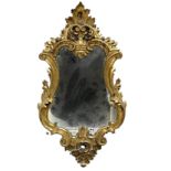 A small carved wooden gilt mirror with distressed glass