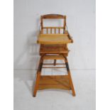 A vintage wooden child's metamorphic high chair