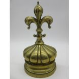 A Victorian brass door stop topped with a fleur de lys, approx. 24cm height