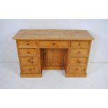 A pine kneehole desk, with cupboard under - length130cm, depth 51cm, height 79cm