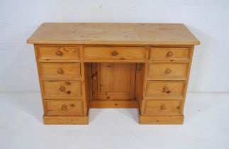 A pine kneehole desk, with cupboard under - length130cm, depth 51cm, height 79cm