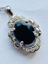 A sapphire and diamond pendant set in 9ct white gold on chain