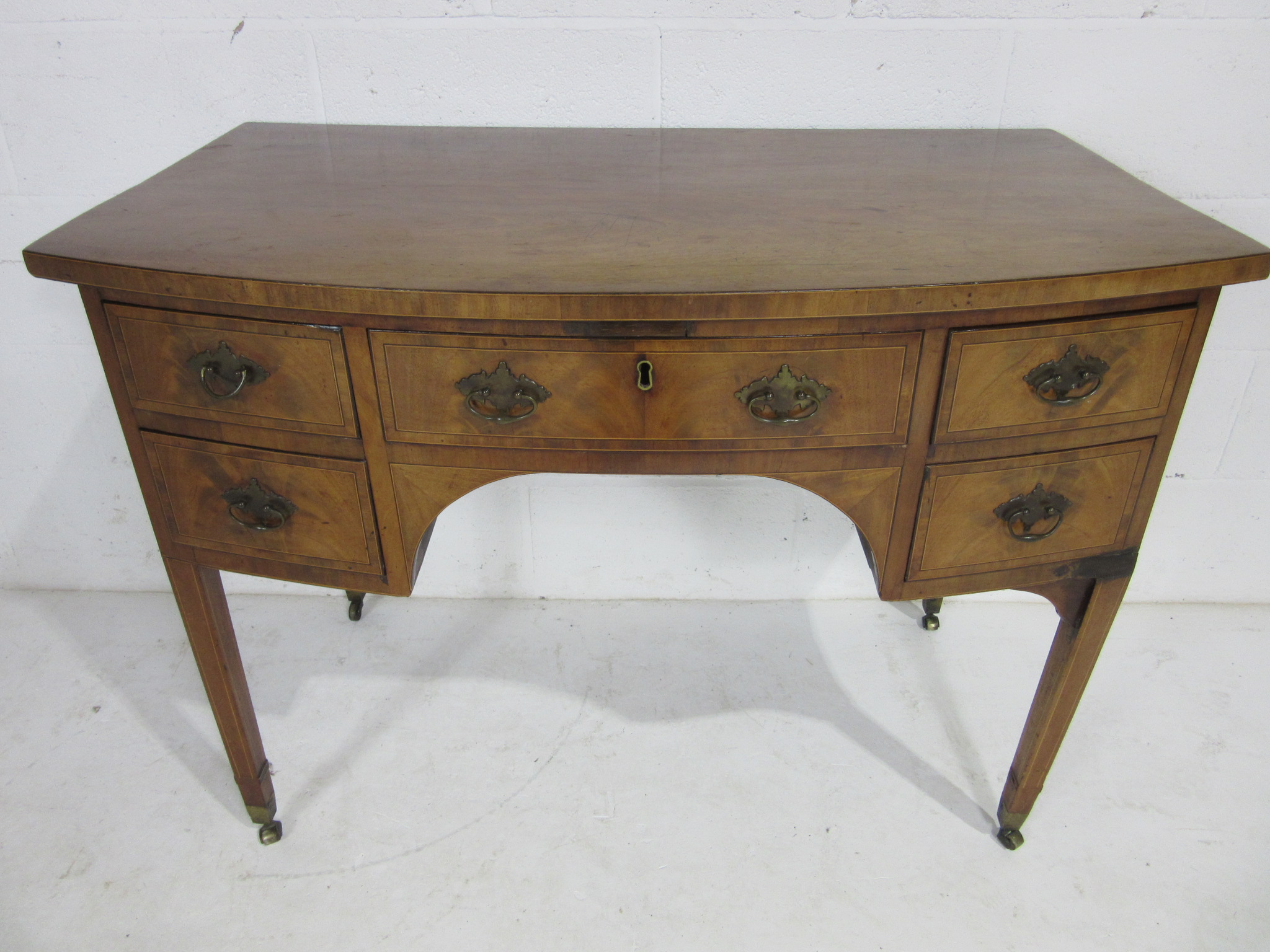 A Georgian bow fronted inlaid mahogany ladies writing desk with 5 drawers