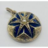 An unmarked gold memorial pendant with enamelled detailing around a central seed pearl