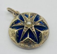 An unmarked gold memorial pendant with enamelled detailing around a central seed pearl