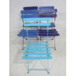 A set of four metal garden folding chairs along with one other similar