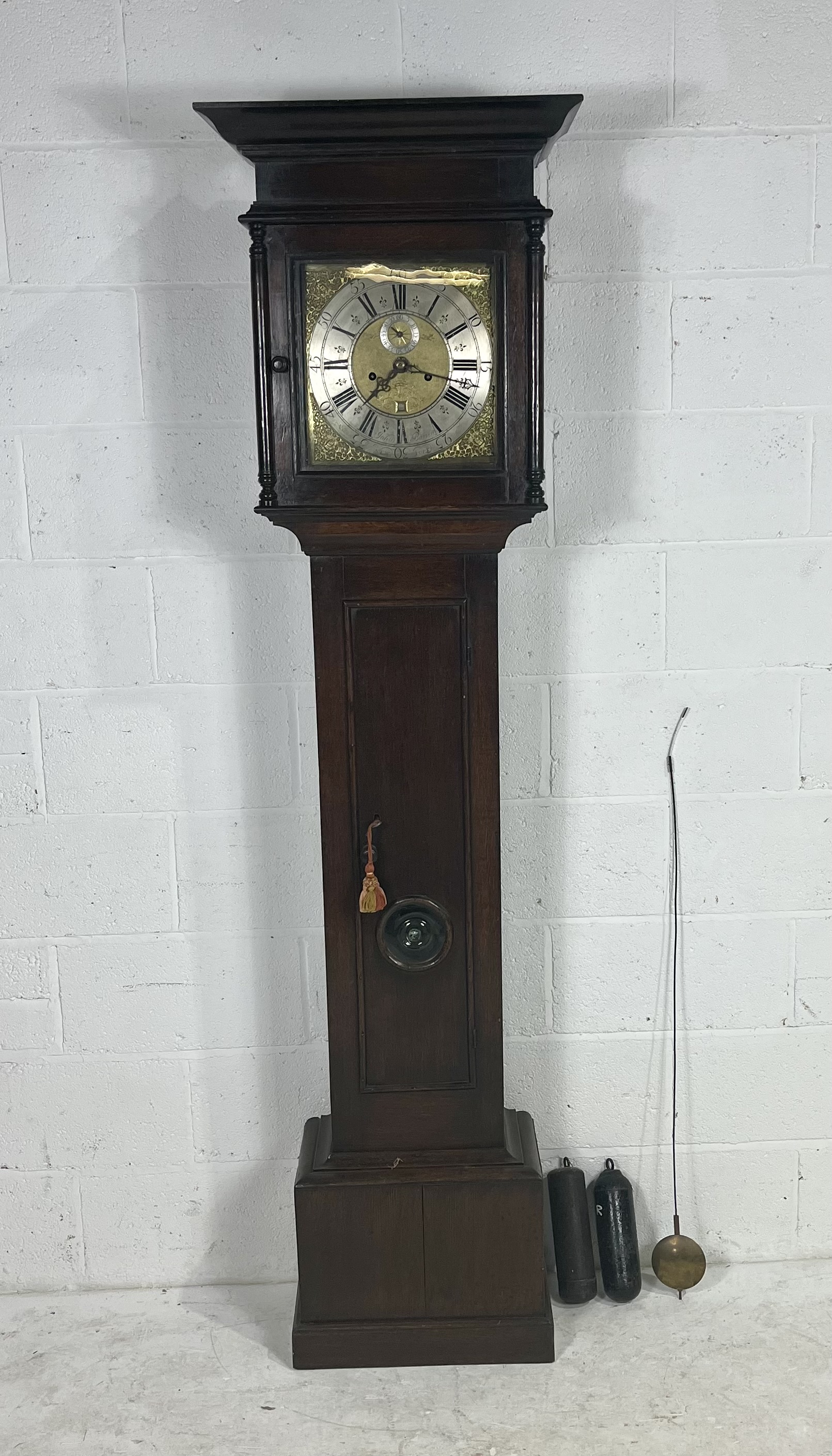 A Georgian oak long case clock with a brass and silvered dial which bears the inscription John