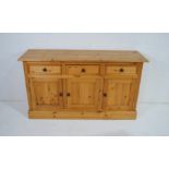 A pine dresser base, with three drawers and cupboard under - length 152cm, depth 46.5cm, height