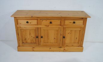 A pine dresser base, with three drawers and cupboard under - length 152cm, depth 46.5cm, height