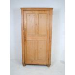 An antique pine larder cupboard, with panelled doors, raised on ball feet - one foot loose but