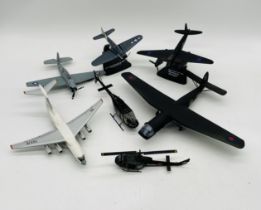 A small collection of die-cast and plastic military aircraft including planes and helicopters