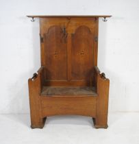 An Arts and Crafts inlaid oak hall stand, with lift up seat to reveal storage, stick stands and coat