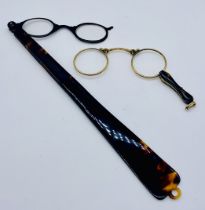 A pair of tortoiseshell spring loaded lorgnettes along with a pair of long handled lorgnettes