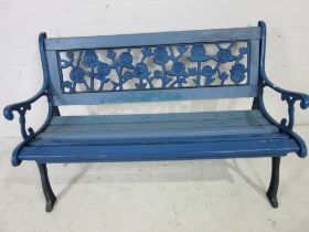 A vintage garden bench with cast iron ends and rose design back panel