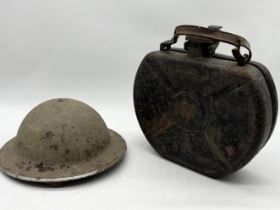 A WW1 era military helmet along with a vintage Sandrik 6L spare wheel jerry can