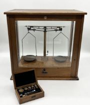 A cased set of vintage Philip Harris & Co scales with sliding glass door along with a cased set of