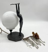 An Art Deco metal table lamp in the form of a nude female with arms outstretched, marked "British