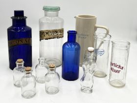 Two antique apothecary jars with labels along with a number of other measures, glass bottles etc.