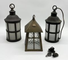 A pair of brass framed lanterns along with one other