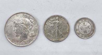 A collection of three coins comprising of 1922 "Peace" dollar, 1942 half dollar etc.