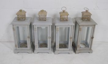 Four painted wooden candle lanterns