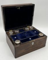 A Victorian rosewood dressing table set with a number of glass bottles, SCM topped bottles and