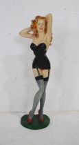 A painted resin figure of a pin-up girl in short black dress - height 89cm