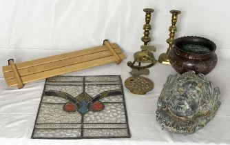 A collection of various items including brass candlesticks, stained glass panel, wall planter in the