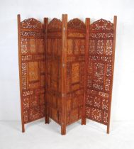 An Eastern teak four fold screen, with pierced decoration - dimensions of each panel: length 50.5cm,