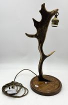 An antler table lamp on wooden base