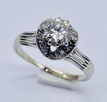 A diamond ring, the central stone of approx. 0.75ct with a surround of 12 small diamonds set in