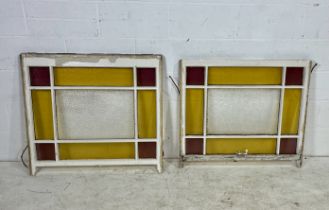 A pair of vintage sash windows with red and green coloured glass panels.