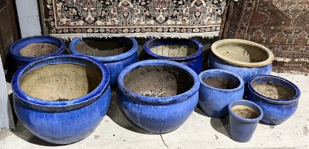 A collection of nine large blue glazed planters and pots