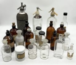 A collection of various glass chemist's bottles along with three vintage soda syphons