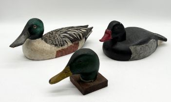 Two handmade carved wooden decoy ducks (shoveler and rosybill) along with a carved mallard head