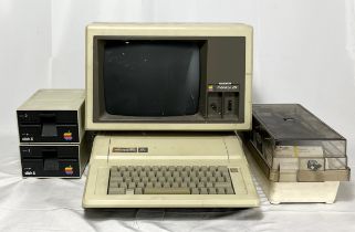 An original Apple II computer with two disk drives along with an Apple III monitor and a